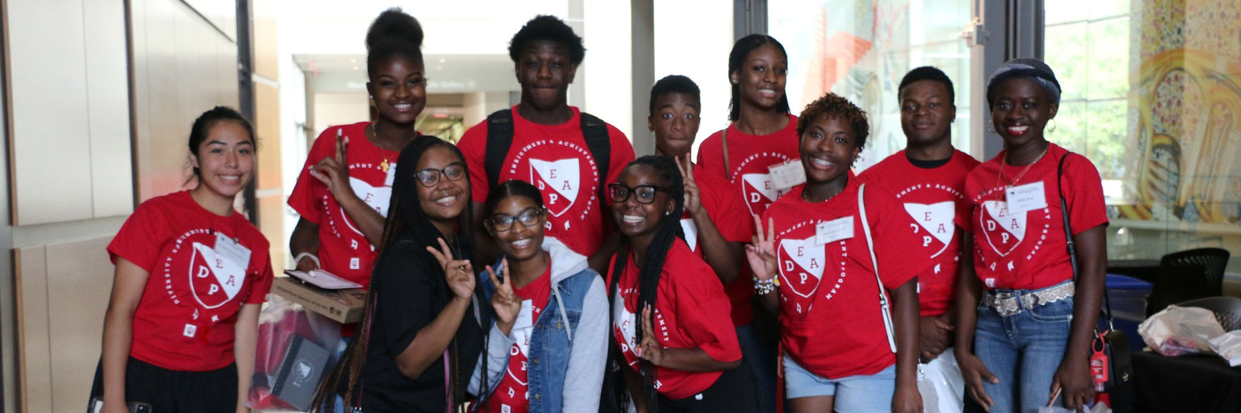 Group photo of multiple students wearing red DEAP shirts